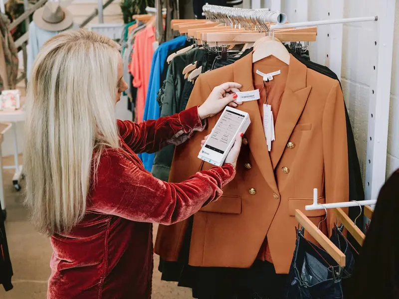 A store associate scans the tag on a jacket with a Clover Flex on the sales floor
